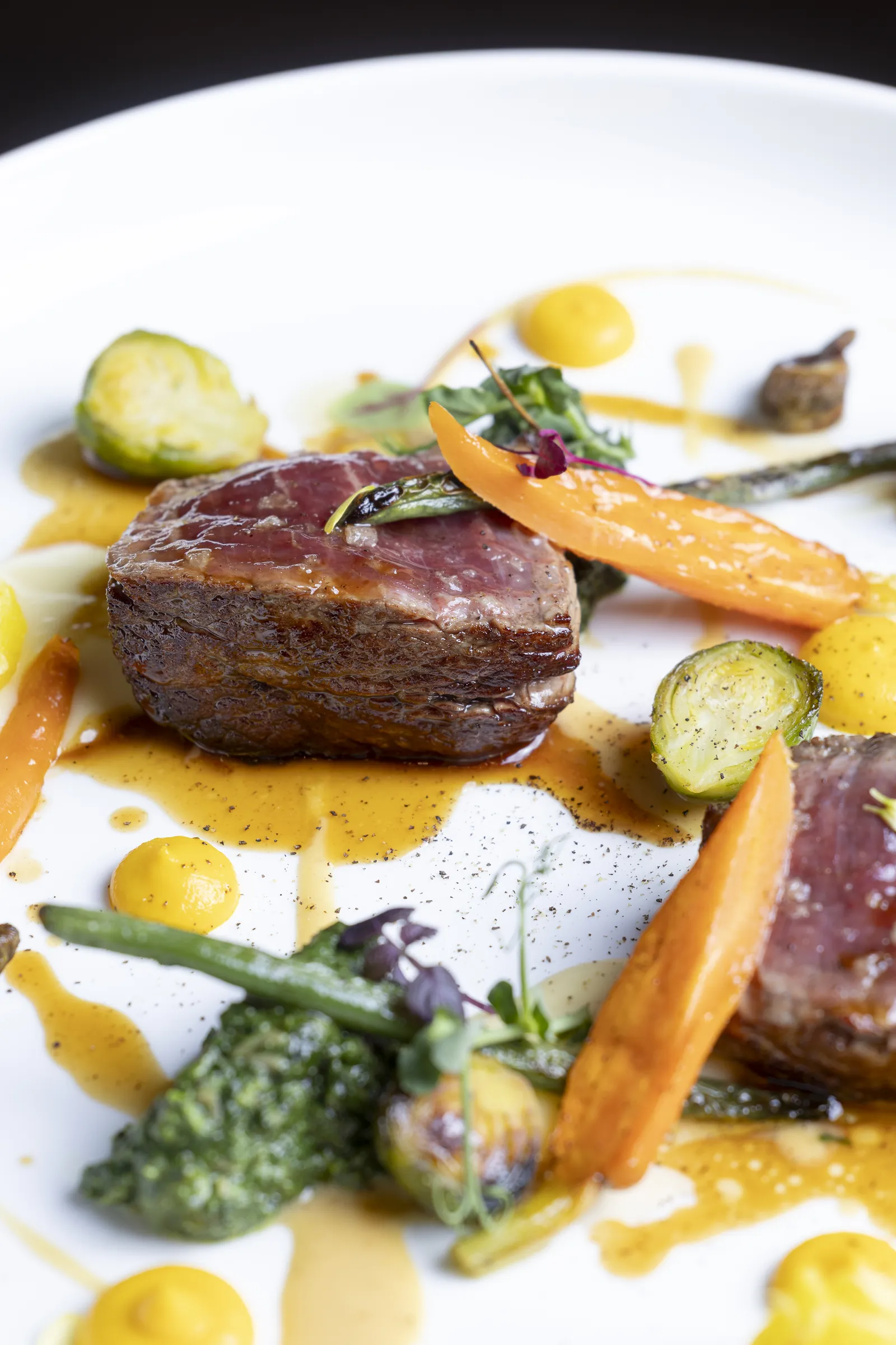 Rosa gegartes Rindfleisch mit Karotten, Rosenkohl und Jus