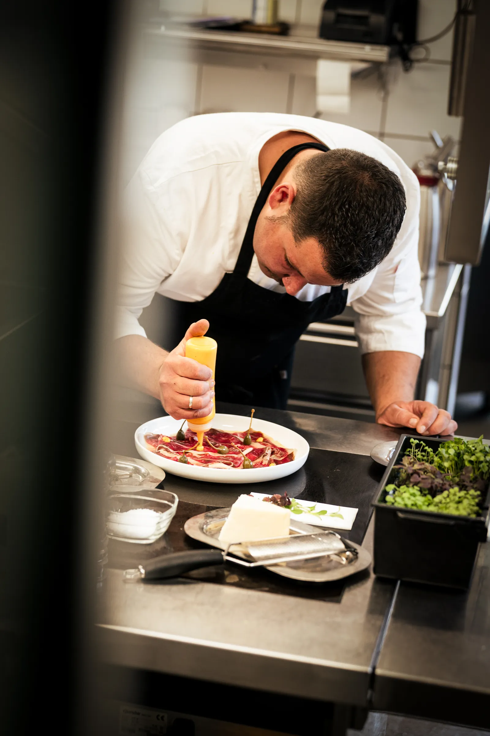 David Arellano impiatta un carpaccio in cucina